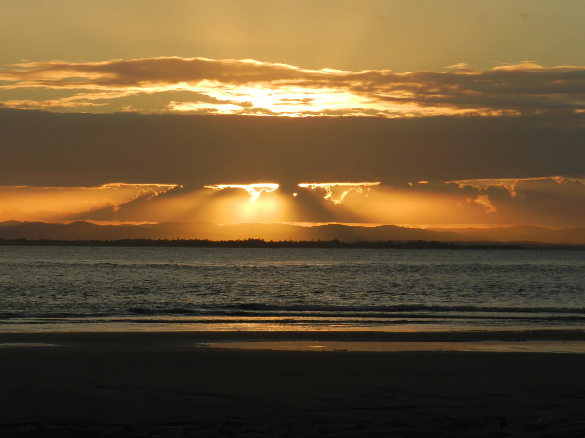Raios de sol atravessando as nuvens sobre o mar no pôr do sol em Barra Grande, na Bahia